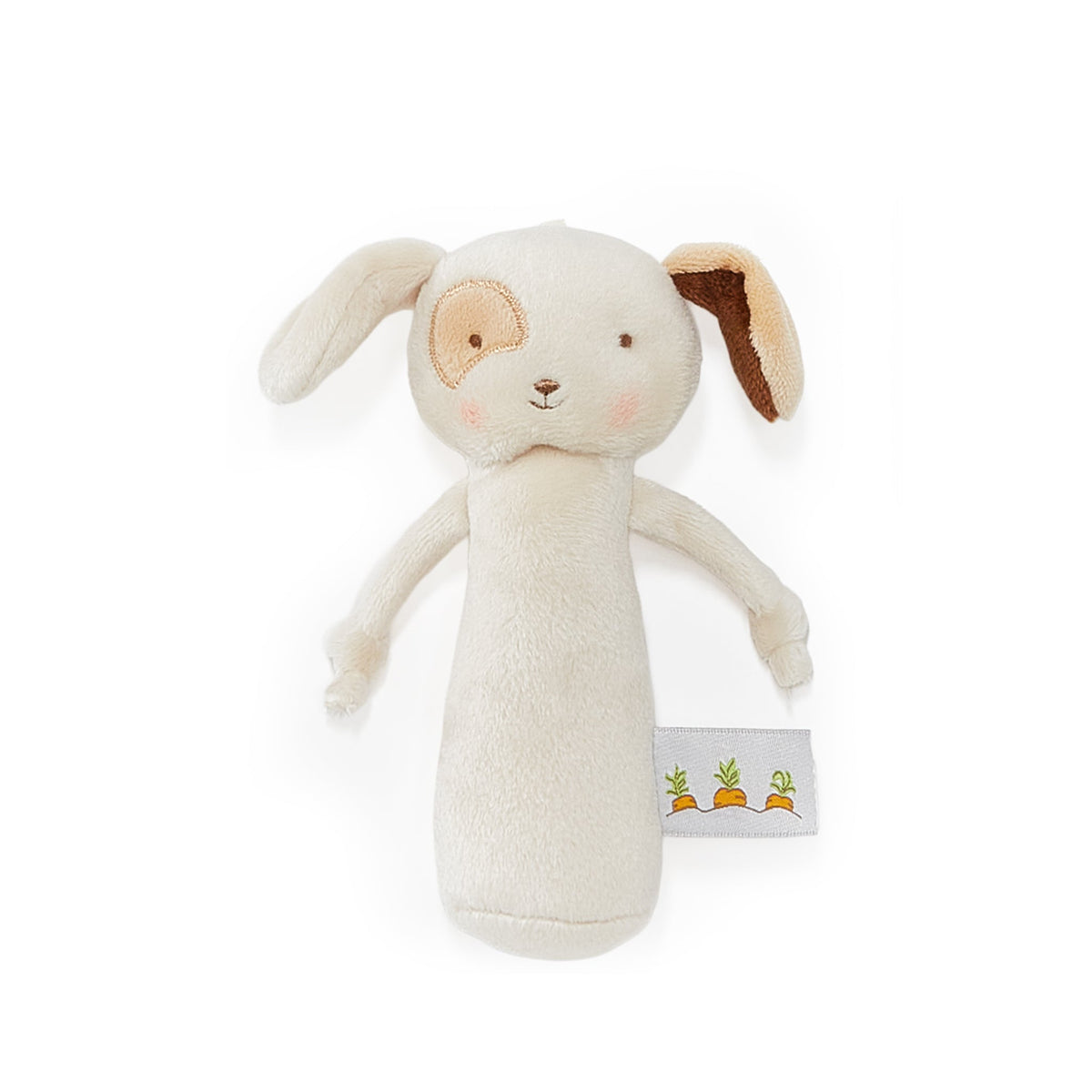 A plush baby puppy rattle with floppy ears, a soft cream body, embroidered facial features, and a small fabric tag near the bottom featuring three carrots.