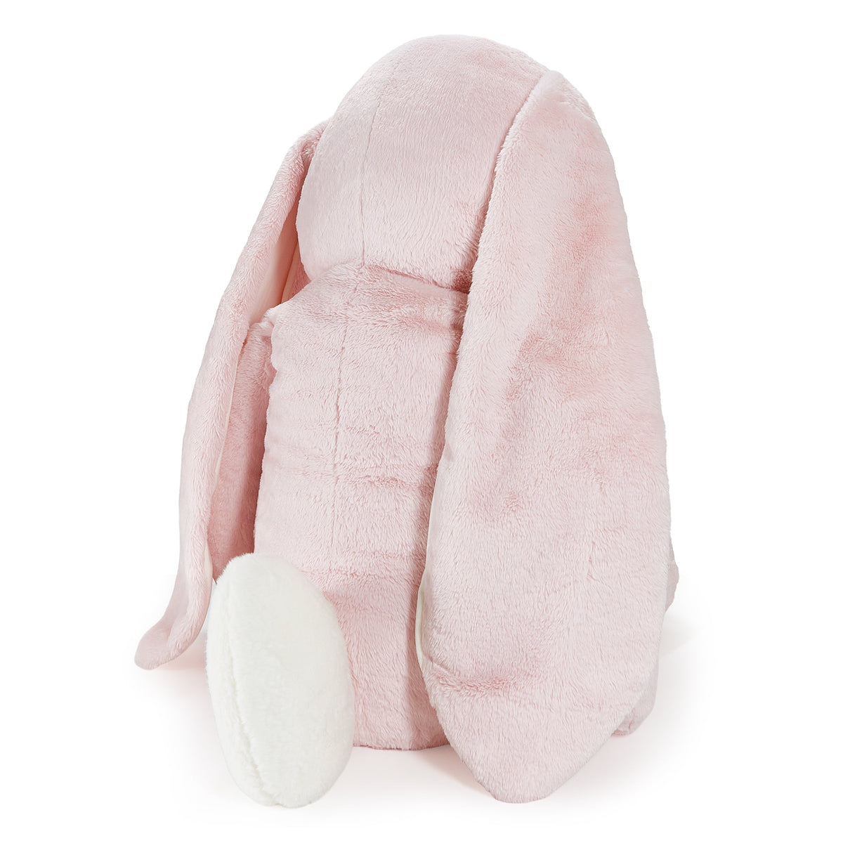 A light pink plush bunny-shaped pillow with long floppy ears and a white foot, photographed on a clean white background.