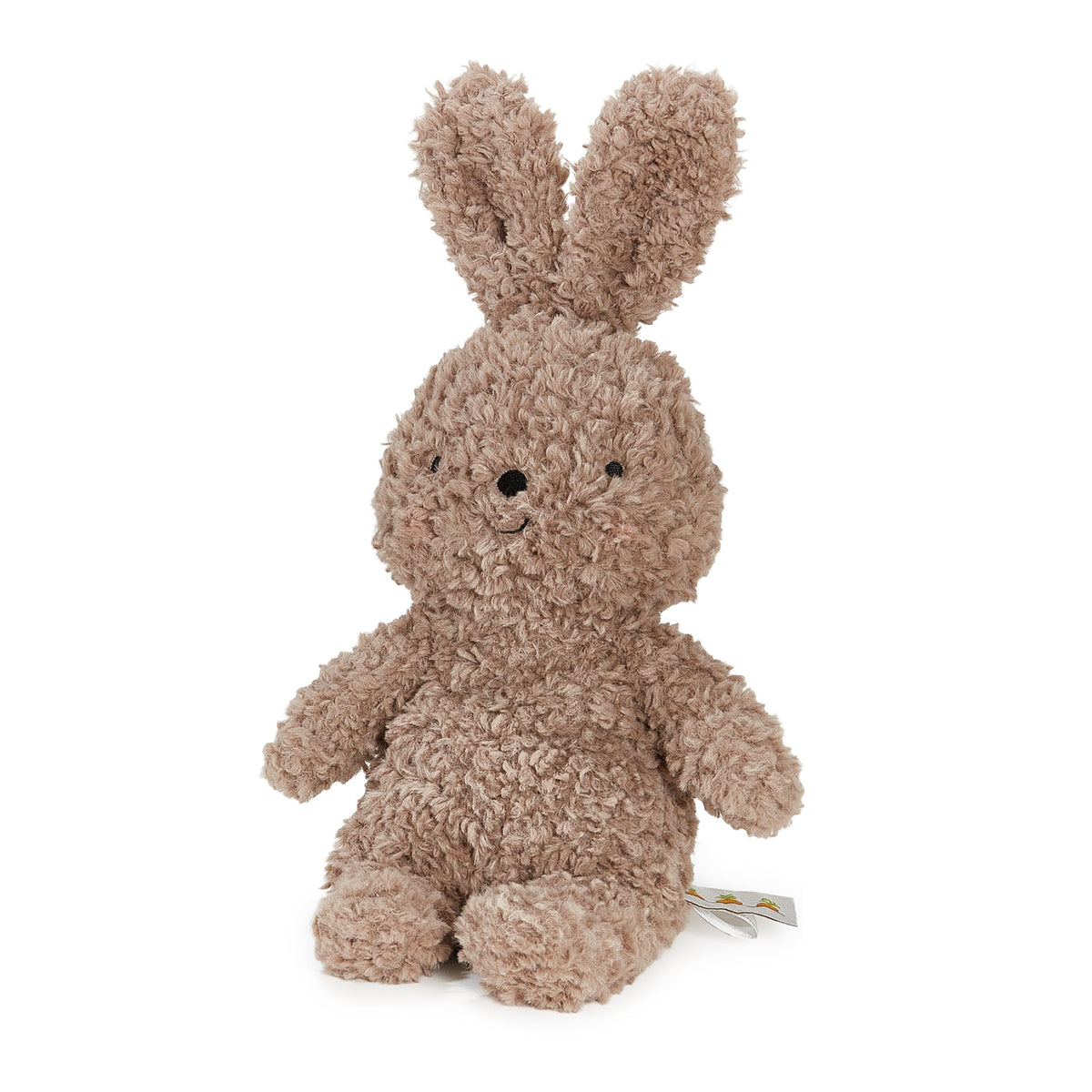 A plush stuffed bunny in a curly, textured light brown fabric, sitting against a solid white background. A small paper tag is attached to its right side.