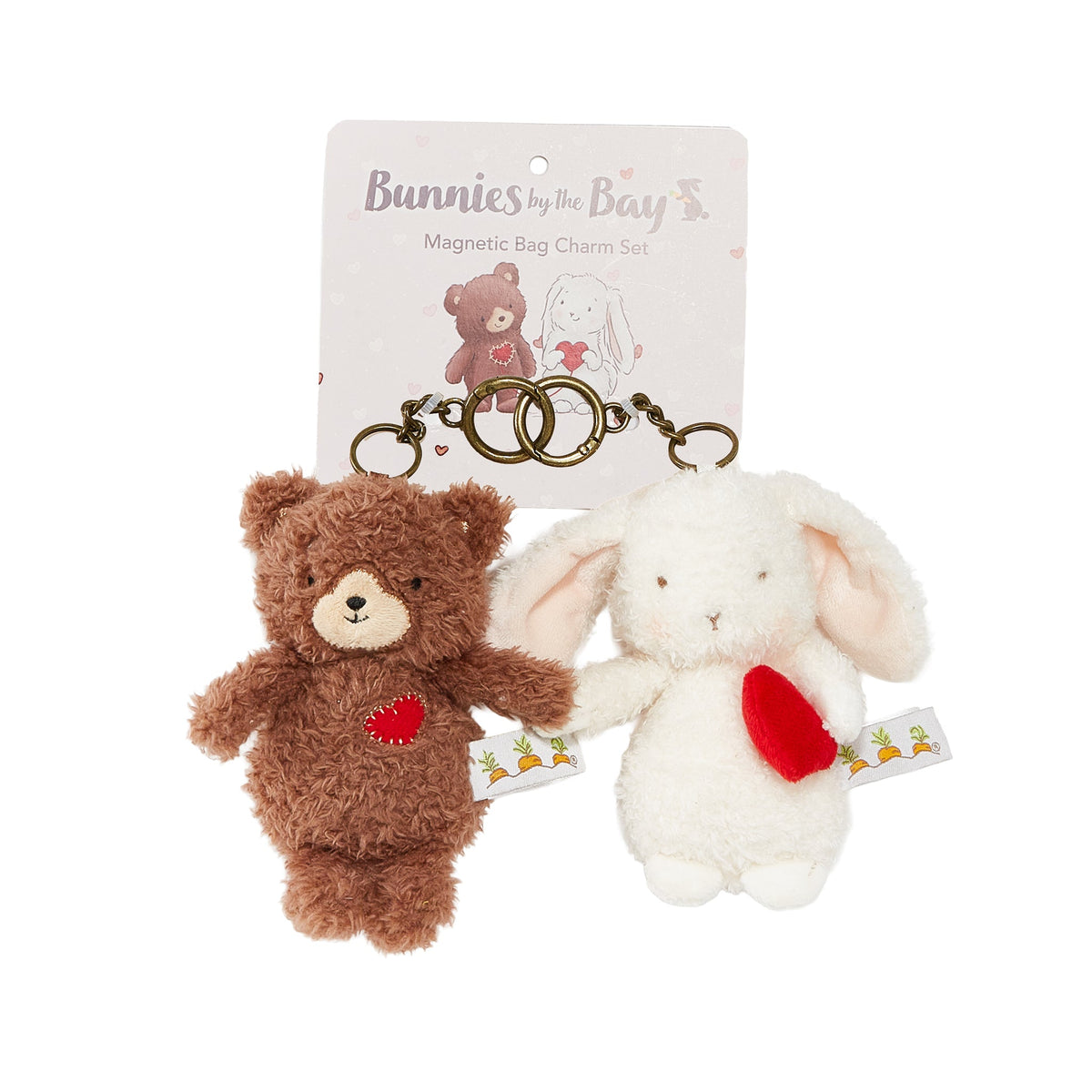 A plush magnetic bag charm set by Bunnies by the Bay, featuring a brown teddy bear with a red heart and a white bunny with a red heart, both attached to gold metal keyrings and displayed in front of their branded backing card.