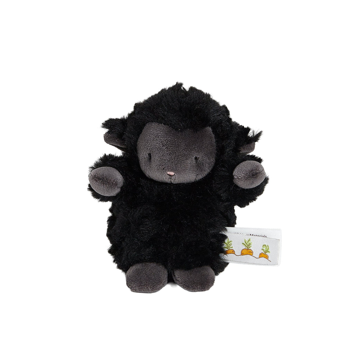 A small black plush sheep toy with a dark gray face, ears, and hooves, sitting against a plain white background. A small white paper tag with carrot illustrations is attached near the bottom right.